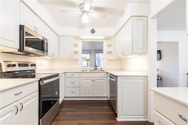 kitchen with ceiling fan, sink, dark wood-type flooring, appliances with stainless steel finishes, and white cabinets