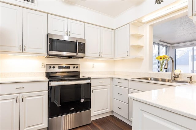 kitchen featuring appliances with stainless steel finishes, ornamental molding, white cabinetry, and sink