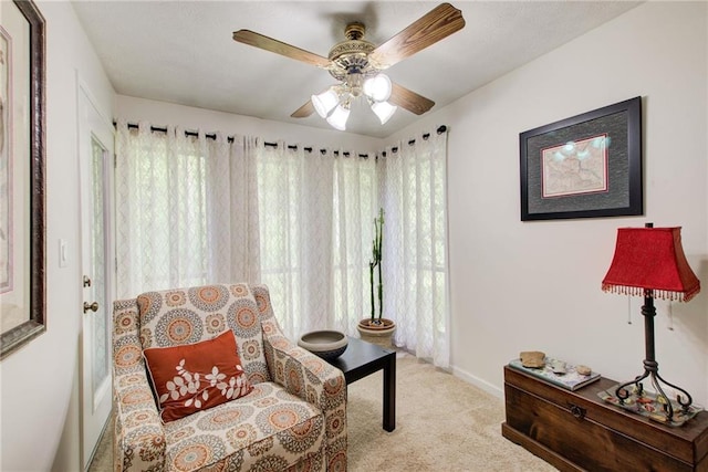 sitting room featuring a wealth of natural light, light colored carpet, and ceiling fan