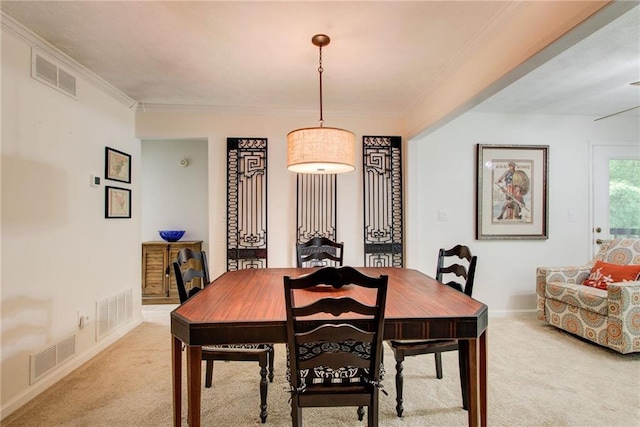 dining space with light carpet and crown molding