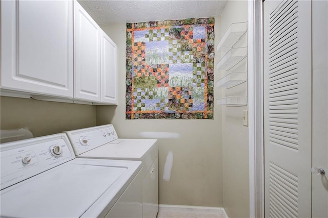 laundry area with cabinets, a textured ceiling, and separate washer and dryer