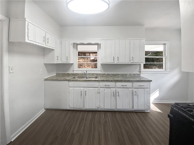 kitchen with black gas range oven, sink, dark hardwood / wood-style floors, and white cabinets