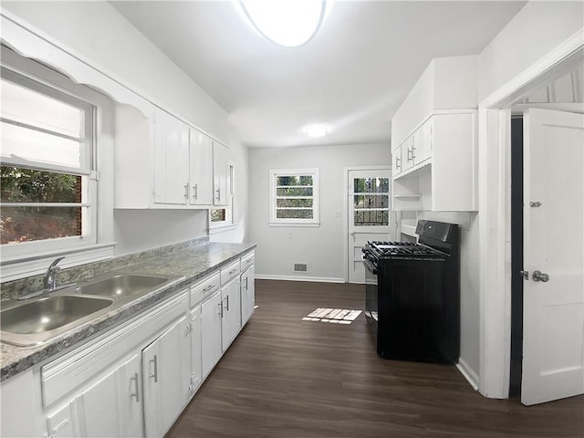 kitchen featuring white cabinetry, dark hardwood / wood-style flooring, black gas stove, and sink