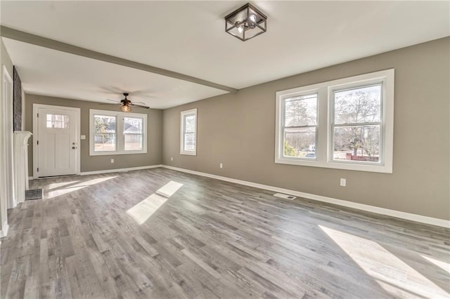 unfurnished living room with light wood-style floors, ceiling fan, and baseboards