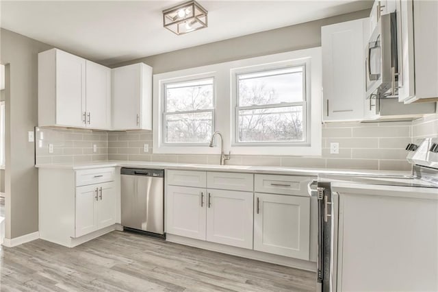 kitchen featuring light countertops, appliances with stainless steel finishes, a sink, and white cabinetry