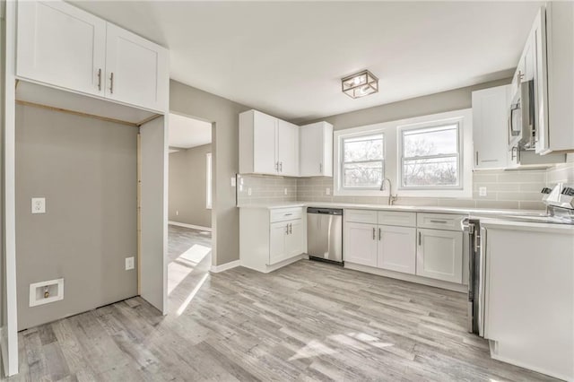 kitchen featuring stainless steel appliances, light wood-type flooring, light countertops, and white cabinetry