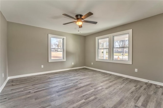 unfurnished room featuring a ceiling fan, light wood-type flooring, and baseboards