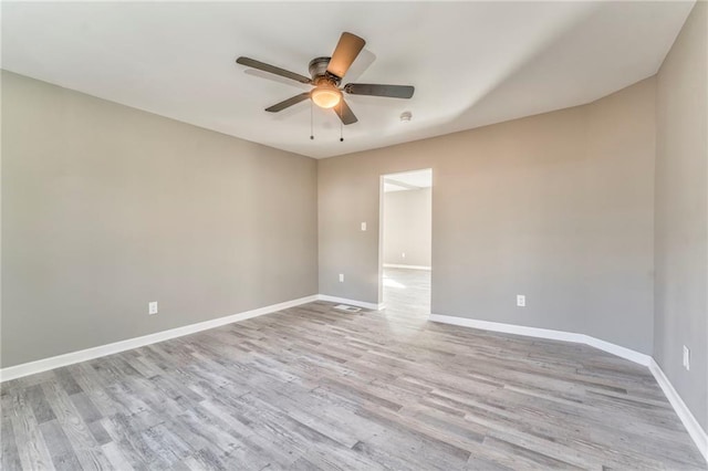 unfurnished room featuring light wood-type flooring, baseboards, and a ceiling fan