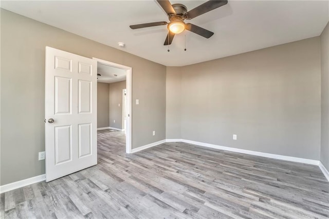 empty room with light wood-style flooring, baseboards, and ceiling fan