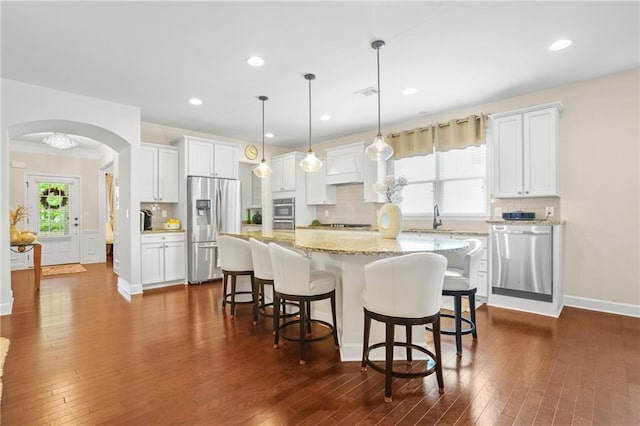 kitchen featuring dark wood-style flooring, stainless steel appliances, decorative backsplash, and white cabinetry
