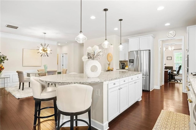kitchen featuring visible vents, a kitchen island, white cabinets, stainless steel fridge with ice dispenser, and dark wood finished floors