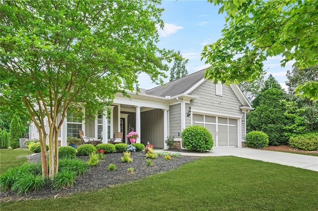 view of front of property featuring a porch, a garage, driveway, and a front yard