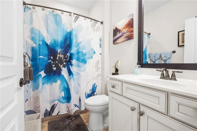 bathroom featuring vanity, toilet, and curtained shower