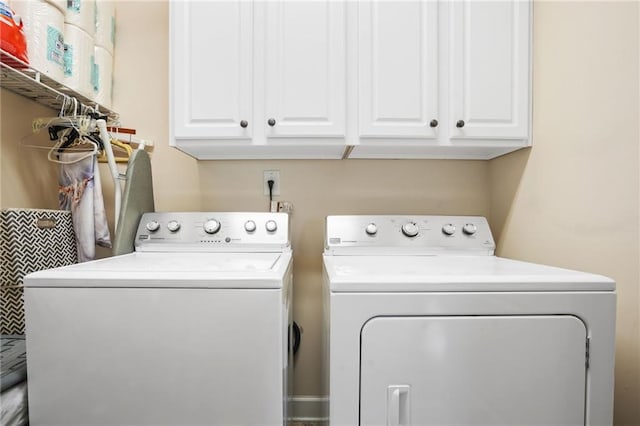 clothes washing area with cabinet space and washing machine and clothes dryer