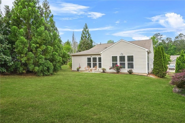 rear view of property featuring a yard