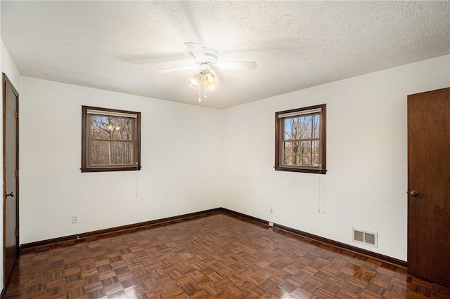 empty room with a ceiling fan, baseboards, and a textured ceiling