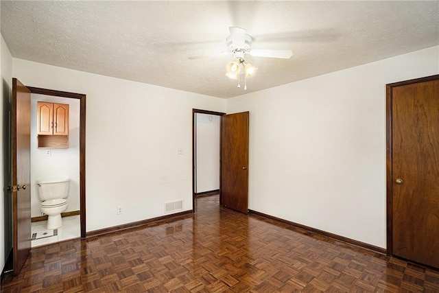 empty room with baseboards, a ceiling fan, and a textured ceiling