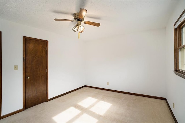 unfurnished room with light colored carpet, baseboards, and ceiling fan