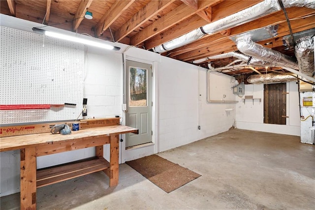 unfinished below grade area featuring a workshop area and concrete block wall