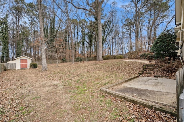 view of yard with a shed, fence, and an outbuilding