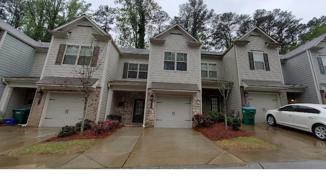 multi unit property featuring concrete driveway, brick siding, and a garage