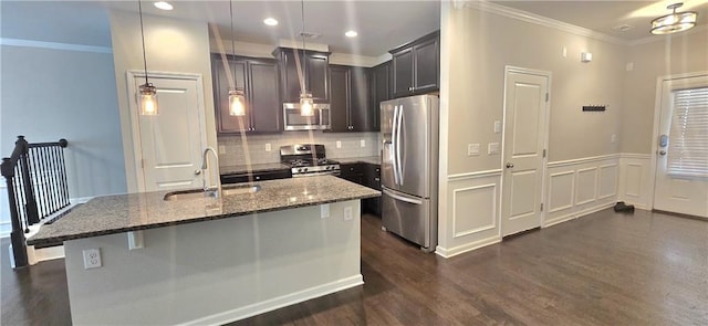 kitchen with a sink, dark stone countertops, dark wood finished floors, backsplash, and appliances with stainless steel finishes