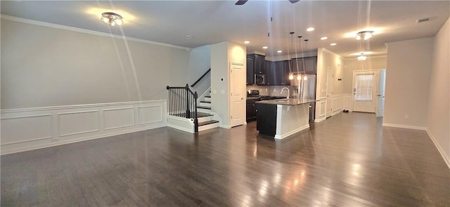 unfurnished living room featuring a ceiling fan, stairs, dark wood-type flooring, ornamental molding, and recessed lighting