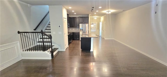 hall featuring stairs, dark wood-style flooring, baseboards, and recessed lighting