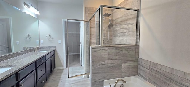 full bath with a sink, double vanity, tiled shower, and a bath