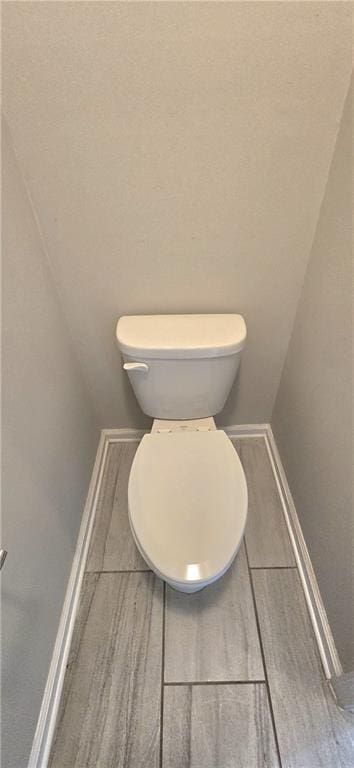 bathroom with toilet and baseboards