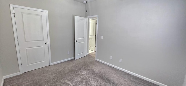 unfurnished bedroom featuring carpet floors and baseboards