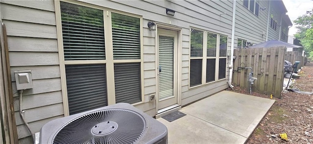 view of patio with central air condition unit and fence