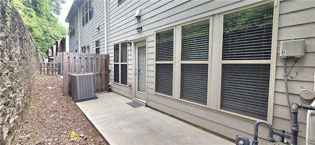 view of home's exterior featuring central air condition unit, fence, and a patio