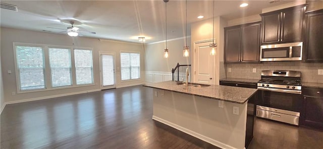 kitchen featuring dark wood-style floors, open floor plan, a ceiling fan, and appliances with stainless steel finishes