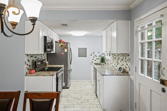 kitchen featuring white cabinets, decorative backsplash, light stone counters, and stainless steel appliances