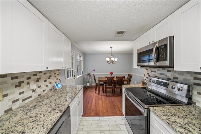 kitchen featuring decorative backsplash, light wood-type flooring, white cabinetry, and stainless steel appliances