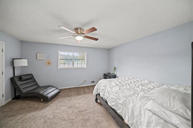 carpeted bedroom with a textured ceiling and ceiling fan