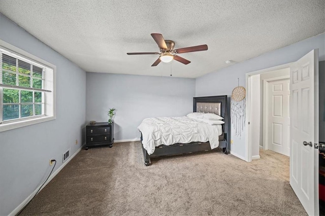 bedroom featuring ceiling fan, carpet floors, and a textured ceiling