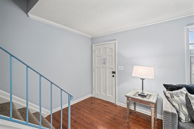 entryway featuring a textured ceiling, dark hardwood / wood-style floors, and ornamental molding