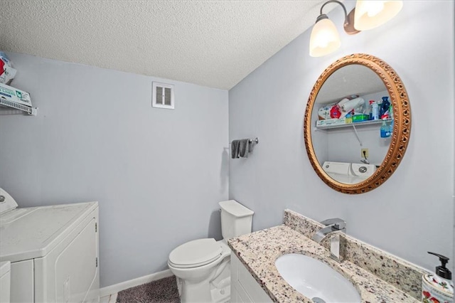 bathroom with vanity, toilet, and a textured ceiling