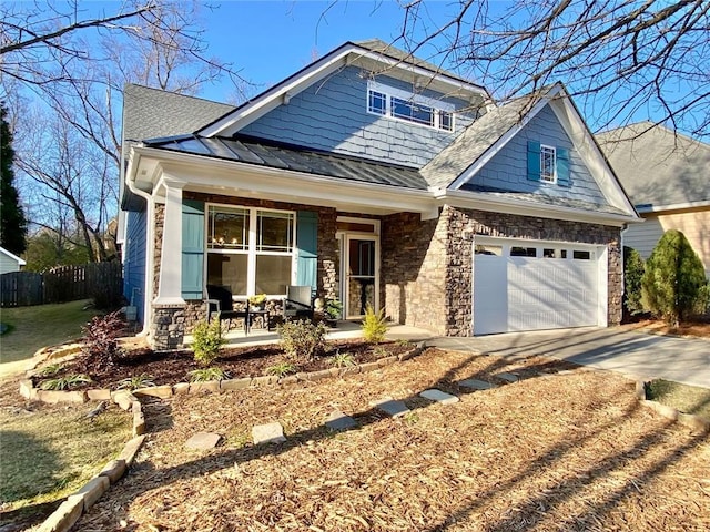 craftsman-style home featuring fence, a standing seam roof, concrete driveway, stone siding, and metal roof