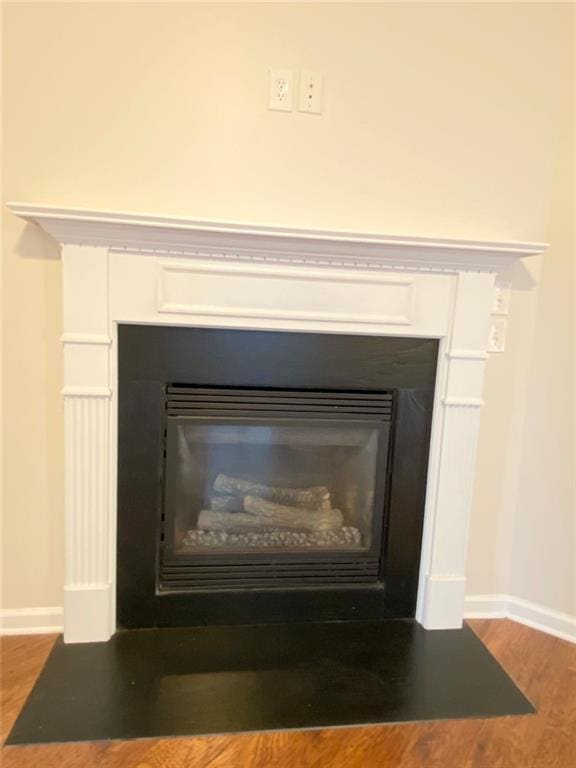 interior details featuring baseboards, a fireplace with flush hearth, and wood finished floors