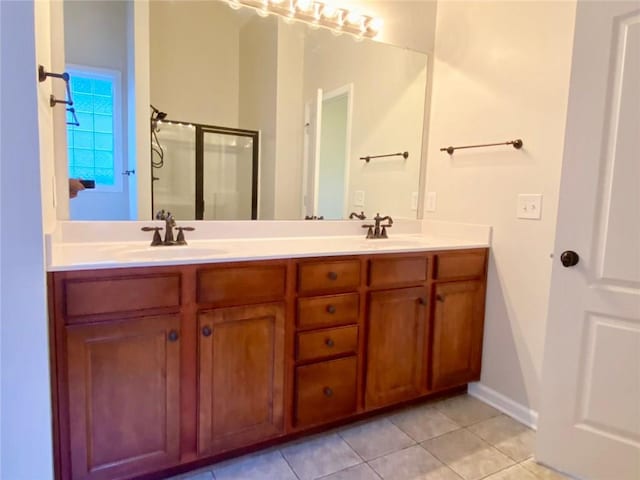 full bath with a sink, double vanity, a shower stall, and tile patterned flooring