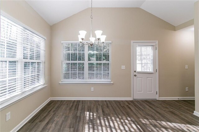 unfurnished dining area featuring a chandelier, vaulted ceiling, and dark wood-type flooring