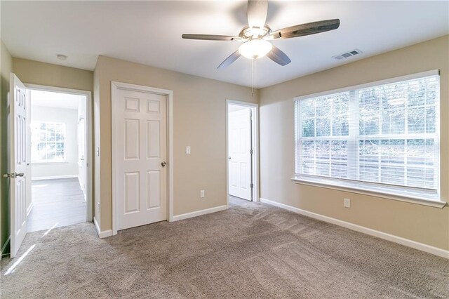 unfurnished bedroom with ceiling fan and light carpet