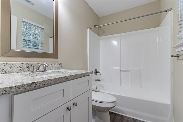 full bathroom featuring toilet, hardwood / wood-style floors, vanity, and bathing tub / shower combination