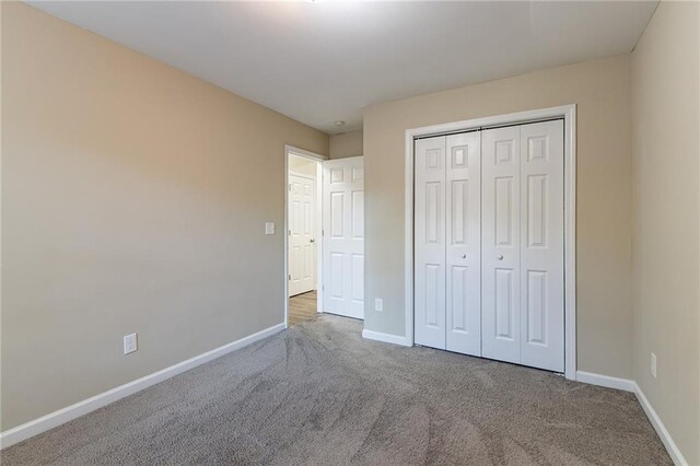 unfurnished bedroom featuring carpet floors and a closet