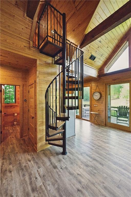 147 Lake Watch Pt, Cleveland, GA 30528 - staircase with wooden walls, high vaulted ceiling, beam ceiling, wooden ceiling, and wood finished floors