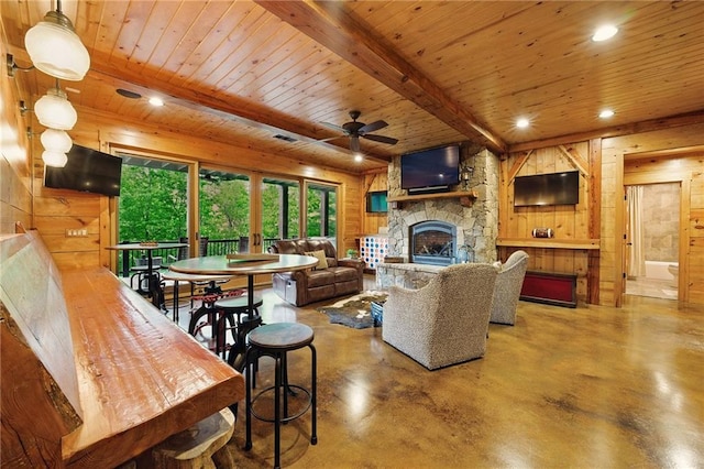 147 Lake Watch Pt, Cleveland, GA 30528 - living area with wooden walls, a stone fireplace, wooden ceiling, concrete floors, and a ceiling fan