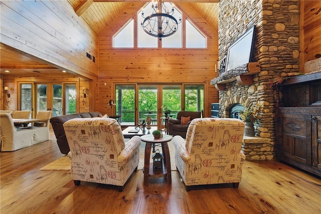 147 Lake Watch Pt, Cleveland, GA 30528 - living area featuring high vaulted ceiling, wooden walls, a chandelier, hardwood / wood-style flooring, and a stone fireplace